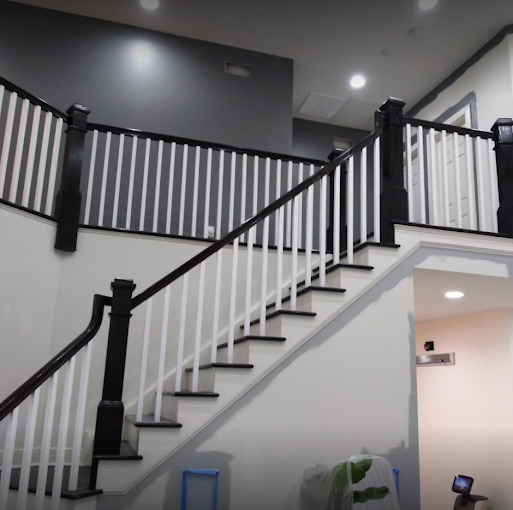 Interior painting and trim — crisp white walls with black-finished staircase railings