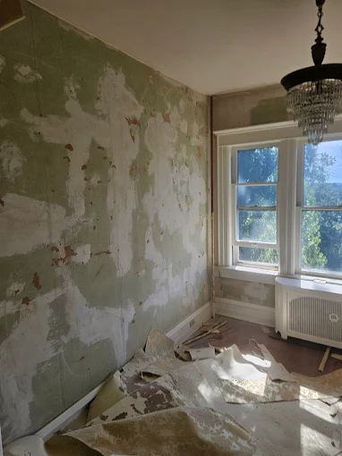Wall restoration in progress — old wallpaper stripped and the surface prepped for a smooth finish